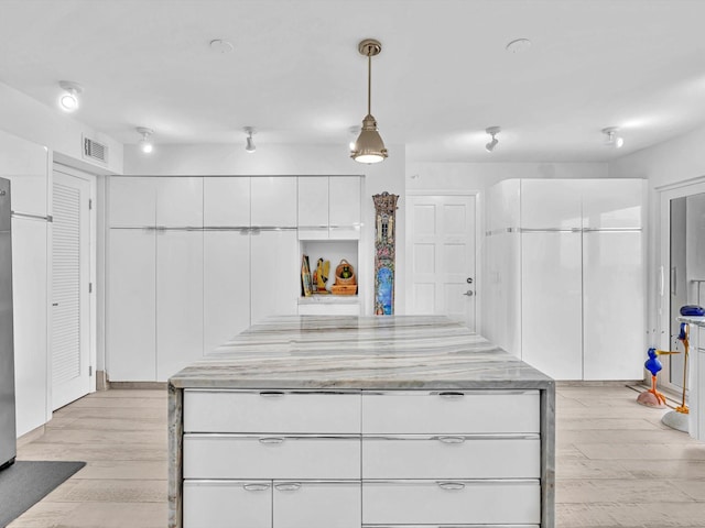 3000 S Ocean Blvd Unit 1504, Boca Raton, FL 33432 - kitchen featuring light wood-style floors, white cabinets, pendant lighting, and light stone countertops