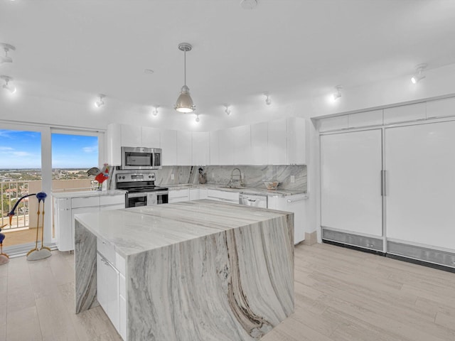 kitchen with white cabinetry, tasteful backsplash, stainless steel appliances, and a center island