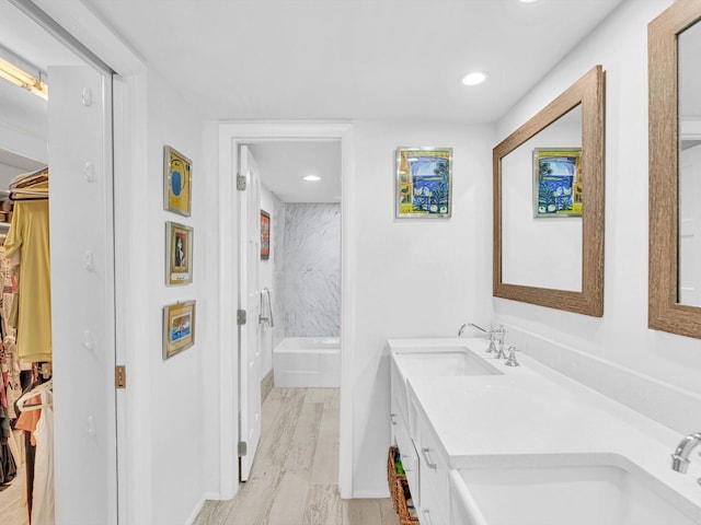 3000 S Ocean Blvd Unit 1504, Boca Raton, FL 33432 - full bathroom with double vanity, a spacious closet, a bath, wood finished floors, and recessed lighting