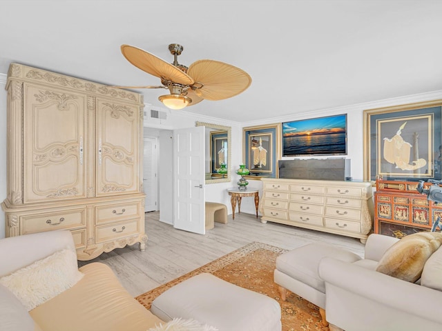 living room featuring crown molding, ceiling fan, and light wood-type flooring