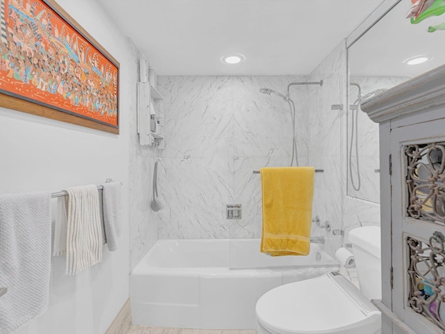 bathroom with tiled shower / bath combo and toilet