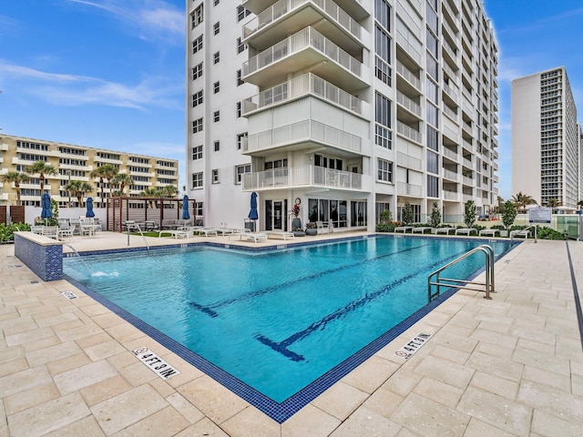 view of swimming pool with pool water feature and a patio area