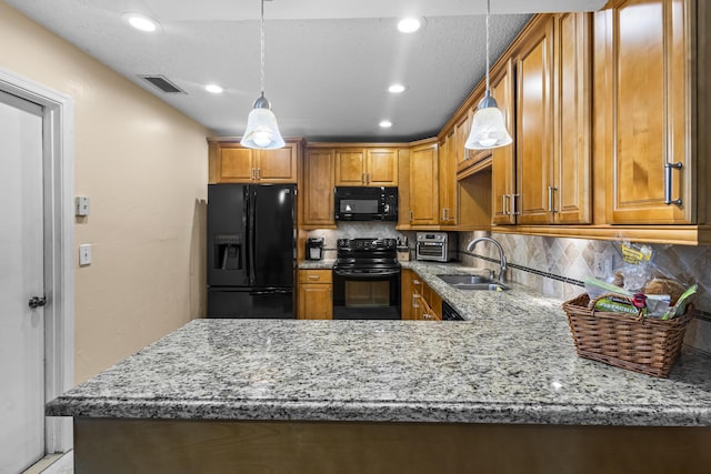 kitchen with decorative light fixtures, tasteful backsplash, sink, black appliances, and light stone countertops