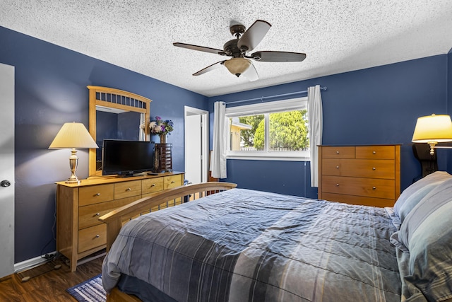 bedroom featuring ceiling fan, dark wood-type flooring, and a textured ceiling