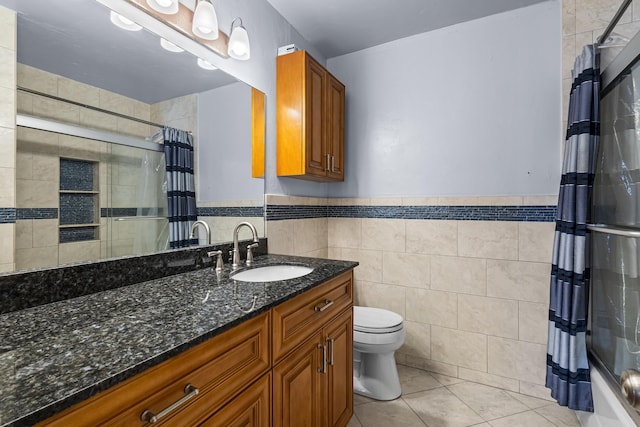 full bathroom with tile patterned floors, toilet, tile walls, vanity, and shower / bath combo