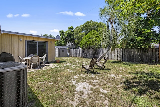 view of yard featuring central AC unit and a shed