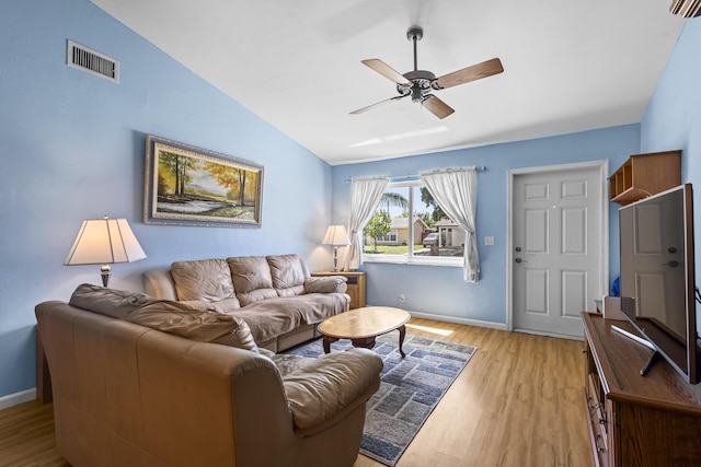 living room with lofted ceiling, ceiling fan, and light wood-type flooring