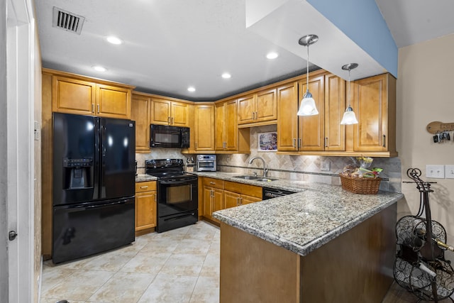 kitchen with sink, decorative light fixtures, kitchen peninsula, light stone countertops, and black appliances