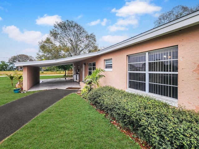 exterior space with a carport and a front lawn