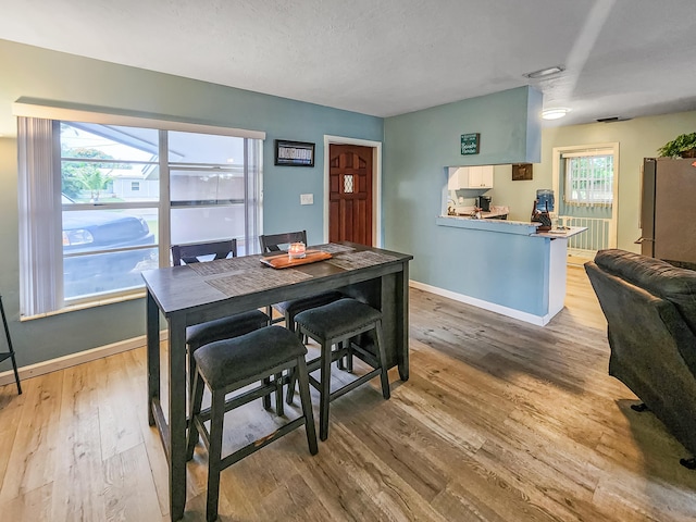 dining area with hardwood / wood-style flooring and a textured ceiling