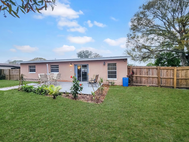 rear view of house with a yard and a patio area