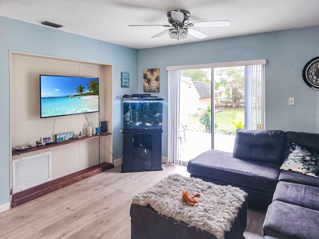 living room featuring hardwood / wood-style floors and ceiling fan