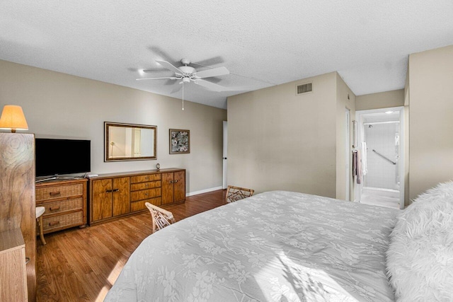 bedroom featuring ceiling fan, hardwood / wood-style flooring, and a textured ceiling