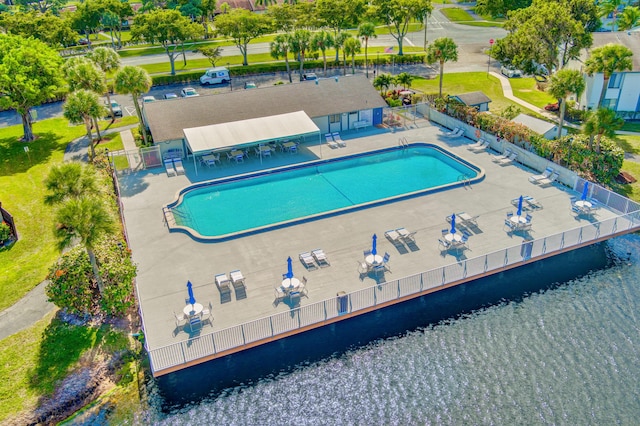 view of pool featuring a water view and a patio area