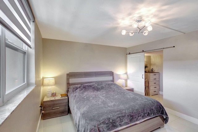 bedroom featuring multiple windows, a notable chandelier, and a barn door