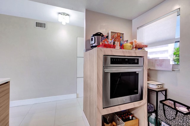 3600 NE 170th St Unit 407, North Miami Beach, FL 33160 - kitchen featuring stainless steel oven, tile patterned floors, baseboards, and visible vents