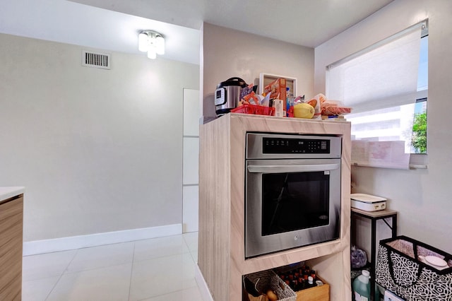 kitchen with oven and light tile patterned floors