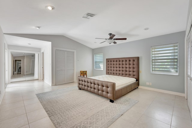 bedroom featuring lofted ceiling, multiple windows, light tile patterned floors, and ceiling fan