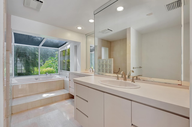 bathroom featuring tiled bath, tile patterned floors, and vanity