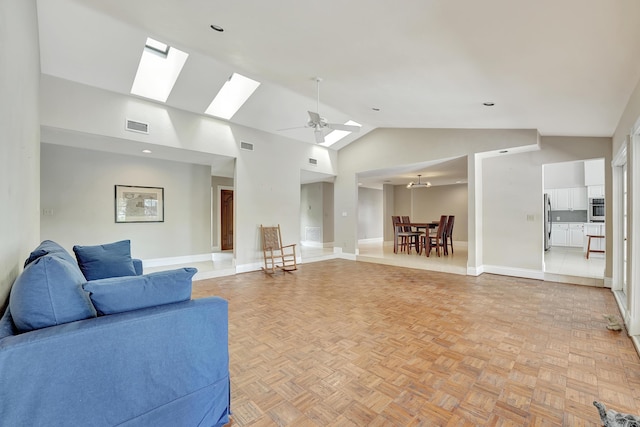 living room featuring light parquet floors, a skylight, high vaulted ceiling, and ceiling fan