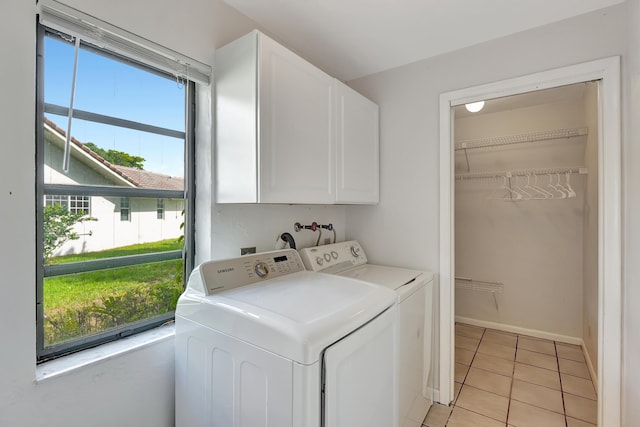 laundry room with washer and dryer, cabinets, and light tile patterned floors