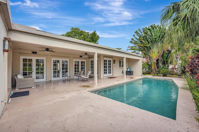 view of swimming pool with a patio area, ceiling fan, and french doors