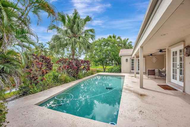 view of swimming pool featuring ceiling fan, french doors, and a patio area