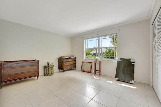 interior space with crown molding and light tile patterned floors