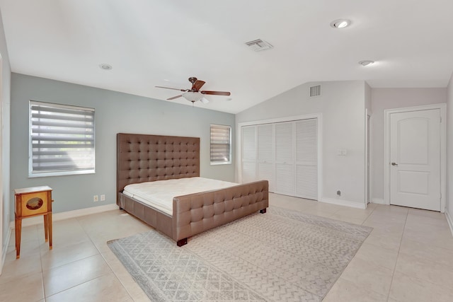 bedroom with light tile patterned floors, a closet, vaulted ceiling, and ceiling fan