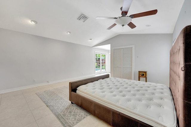 bedroom featuring a closet, ceiling fan, light tile patterned floors, and lofted ceiling