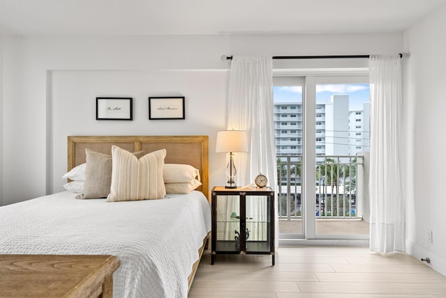 bedroom with multiple windows, hardwood / wood-style floors, and access to exterior