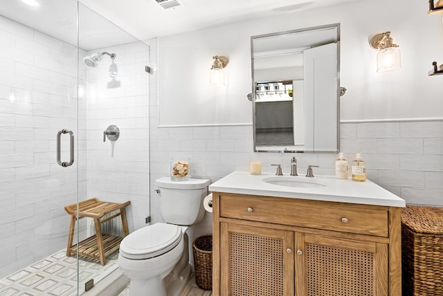 bathroom with walk in shower, vanity, toilet, and tile walls