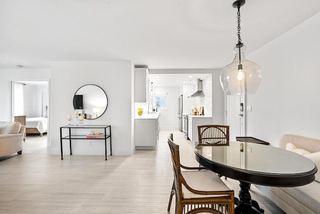 dining space with sink and light hardwood / wood-style floors