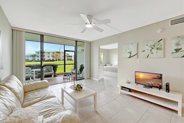 living room with a warm lit fireplace, light tile patterned floors, baseboards, visible vents, and floor to ceiling windows