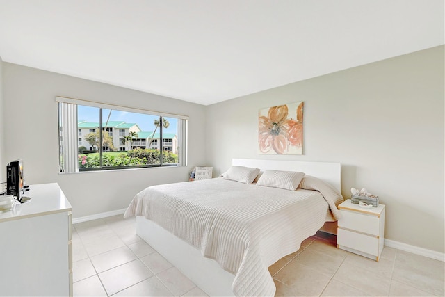 bedroom with baseboards and light tile patterned floors