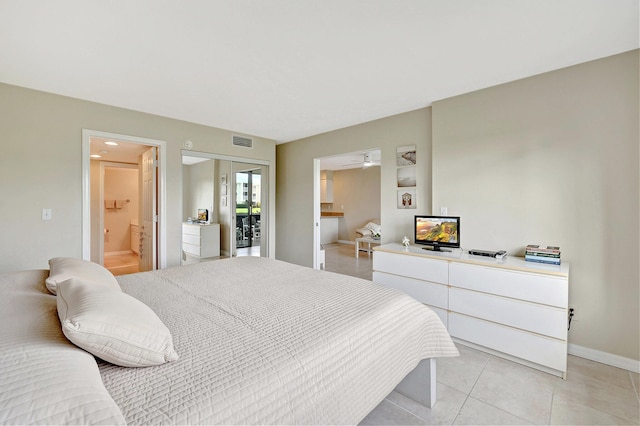 bedroom featuring ensuite bath, visible vents, baseboards, and light tile patterned flooring