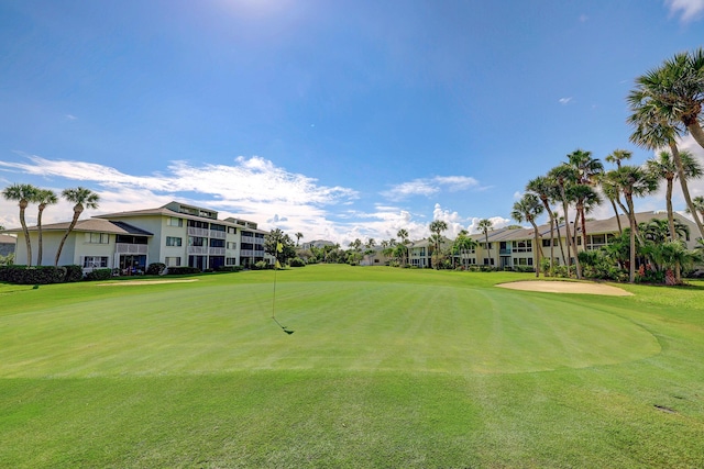 view of property's community with golf course view and a lawn