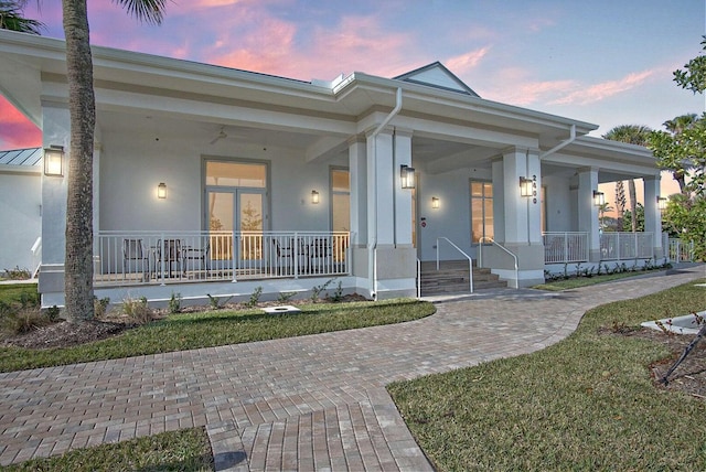 view of front of property featuring covered porch and stucco siding