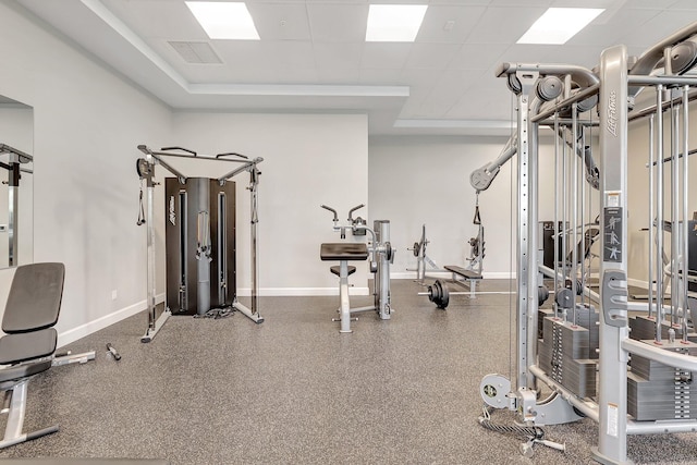 workout area with a paneled ceiling, baseboards, and visible vents