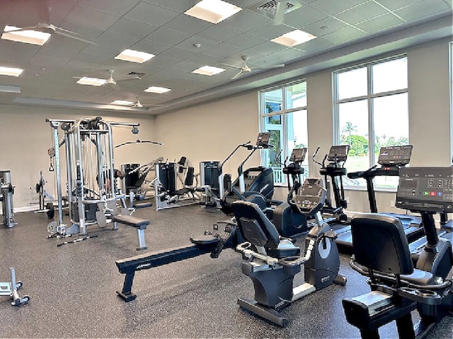 exercise room featuring a paneled ceiling, baseboards, and visible vents