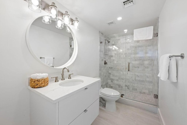 bathroom with toilet, walk in shower, and vanity