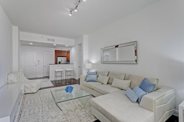 living room with wood-type flooring and track lighting