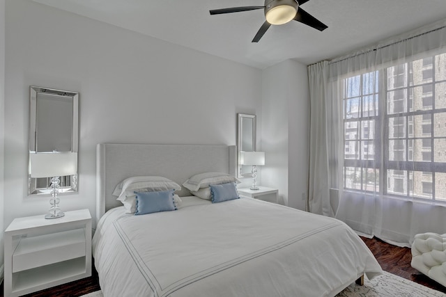 bedroom with dark hardwood / wood-style flooring and ceiling fan