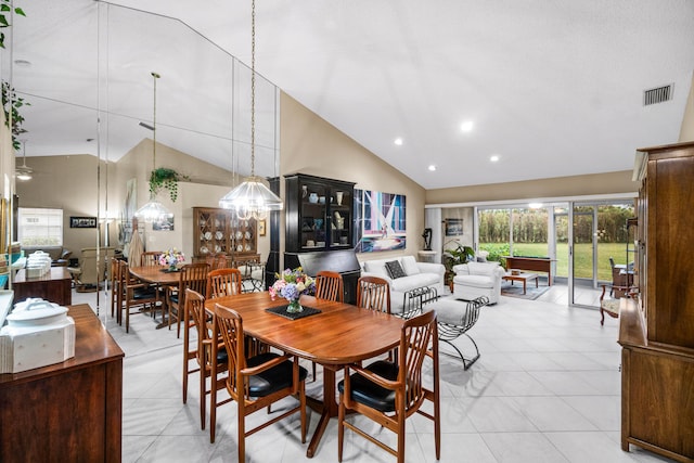 dining area with light tile patterned floors and high vaulted ceiling