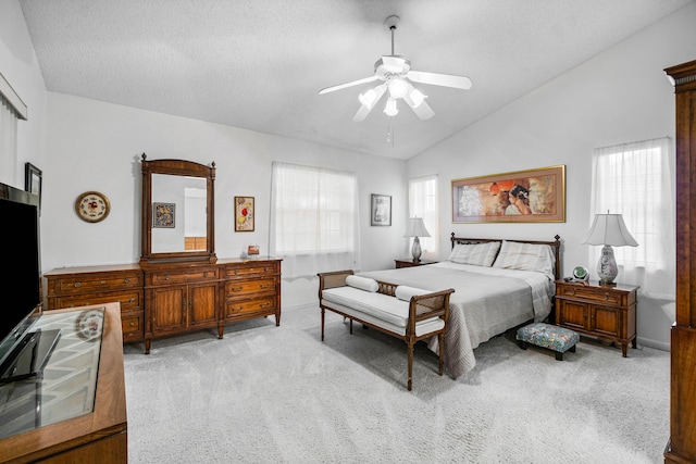 carpeted bedroom featuring vaulted ceiling, a textured ceiling, and ceiling fan