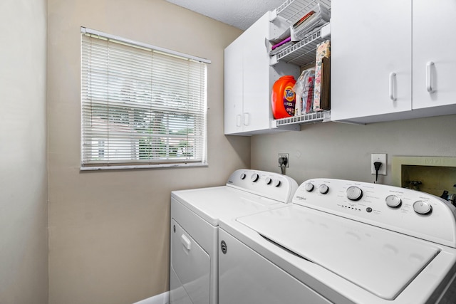 laundry area featuring cabinets, a textured ceiling, and washer and clothes dryer