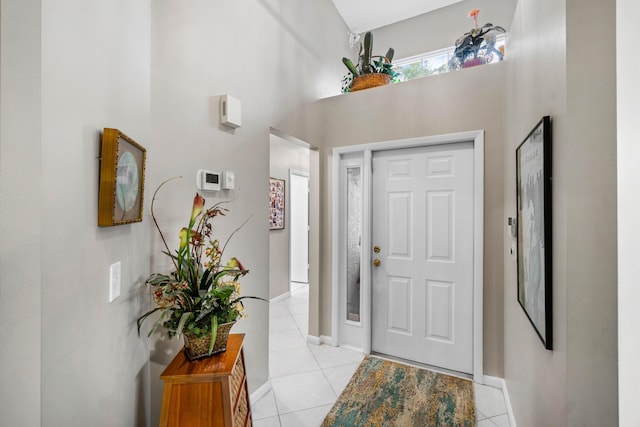 tiled entryway featuring a towering ceiling