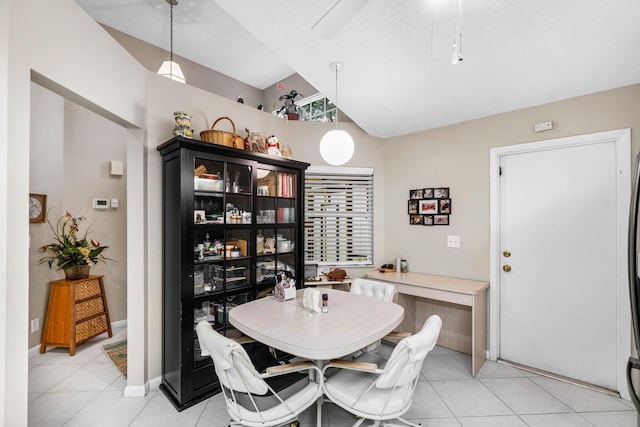 dining area with high vaulted ceiling, a textured ceiling, and light tile patterned floors