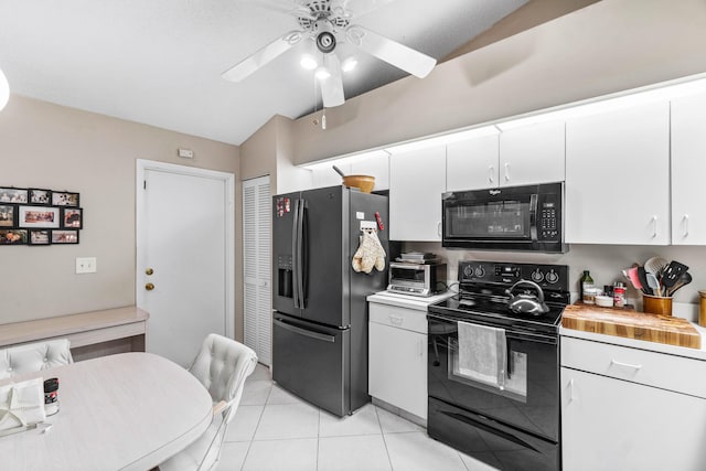 kitchen with light tile patterned flooring, wood counters, lofted ceiling, white cabinets, and black appliances