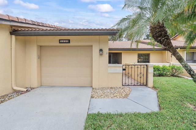 exterior space with a garage, driveway, a tiled roof, a gate, and stucco siding